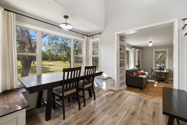 a view of a dining room with furniture large windows and wooden floor
