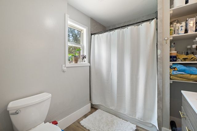a bathroom with a toilet and a shower curtain