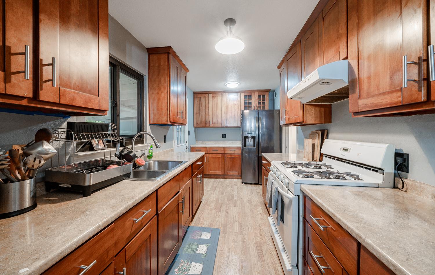 27152 Perkins Road Madera, CA 93637 - Photo 11 of 25 a kitchen with kitchen island granite countertop a sink a counter space stainless steel appliances and cabinets