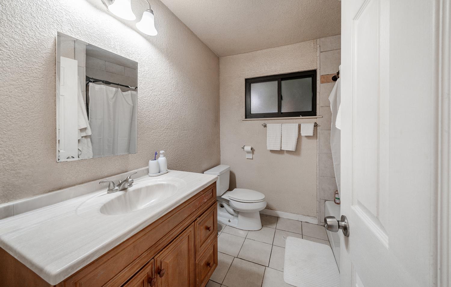 27152 Perkins Road Madera, CA 93637 - Photo 19 of 25 a bathroom with a sink toilet and mirror