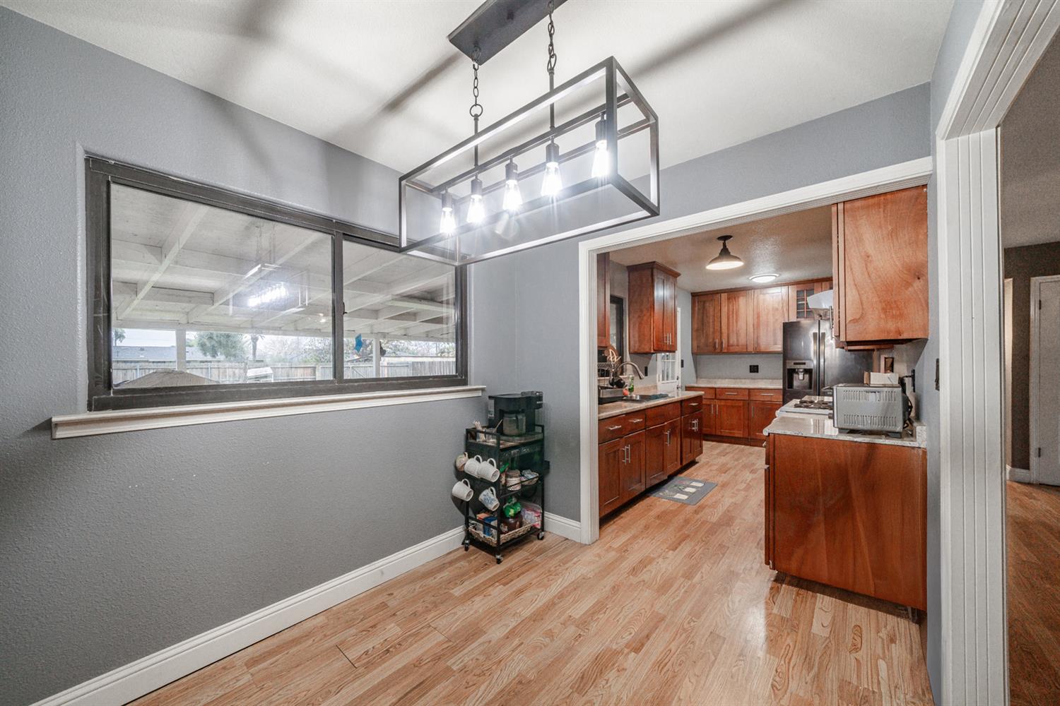 27152 Perkins Road Madera, CA 93637 - Photo 10 of 25 a view of living room and kitchen with furniture wooden floor and windows