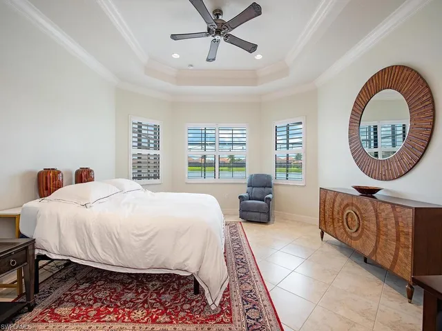a bed sitting in a spacious bedroom next to a window