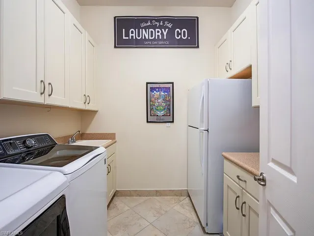 a view of a kitchen with fridge and wooden floor