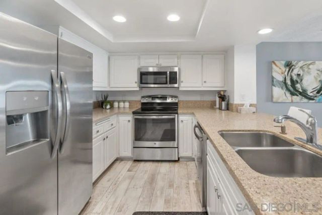 a bedroom with a bed and a potted plant on the dresser