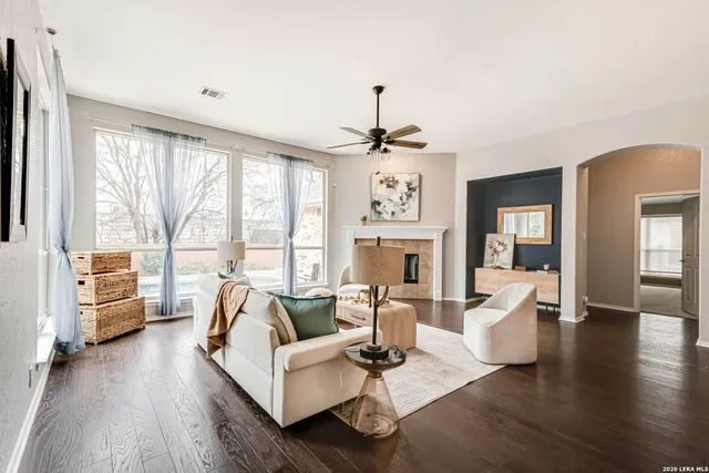 a living room with furniture large window and wooden floor
