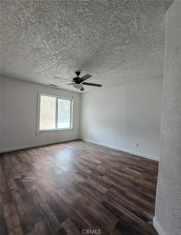 an empty room with windows and fan