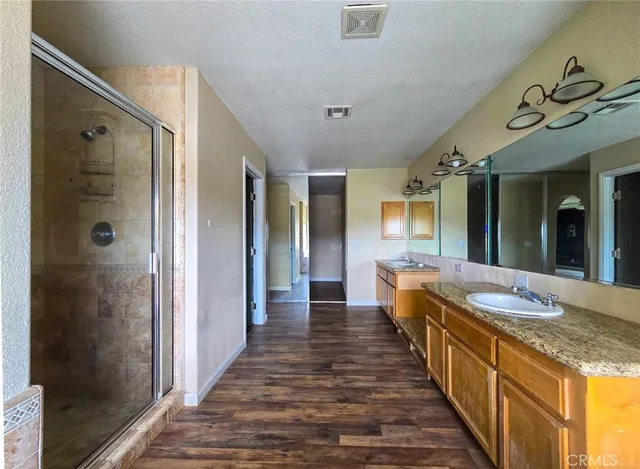 an empty room with wooden floor fireplace and windows