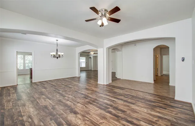 a view of an empty room with window and wooden floor