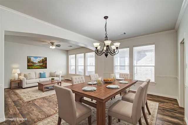 a view of a dining room with furniture a chandelier and wooden floor