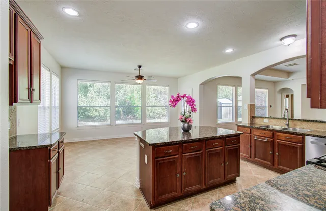a kitchen with granite countertop a sink cabinets and window
