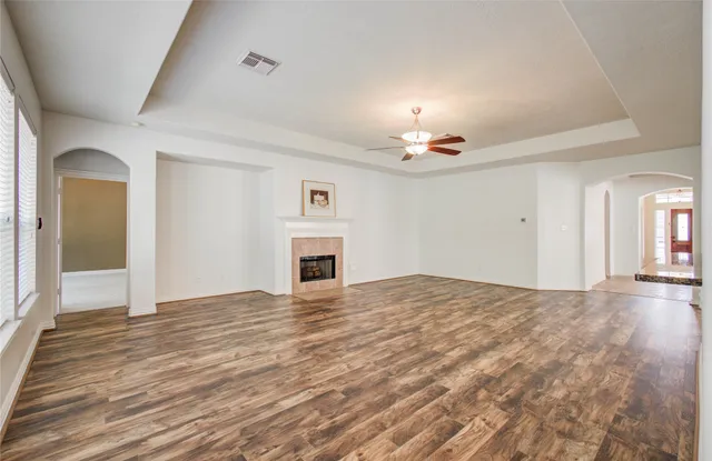 a view of empty room with wooden floor and fireplace