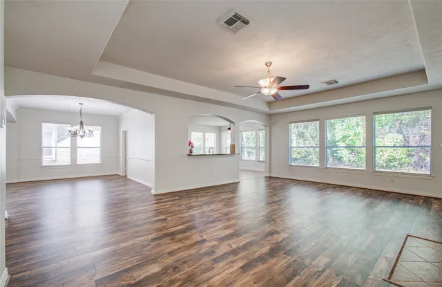 a view of an empty room with a window and wooden floor