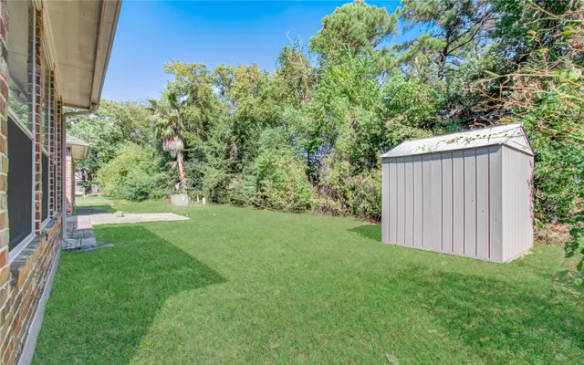 a view of backyard with potted plants and wooden fence