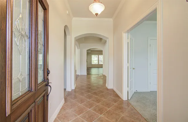 a view of a hallway to a livingroom with furniture and a window