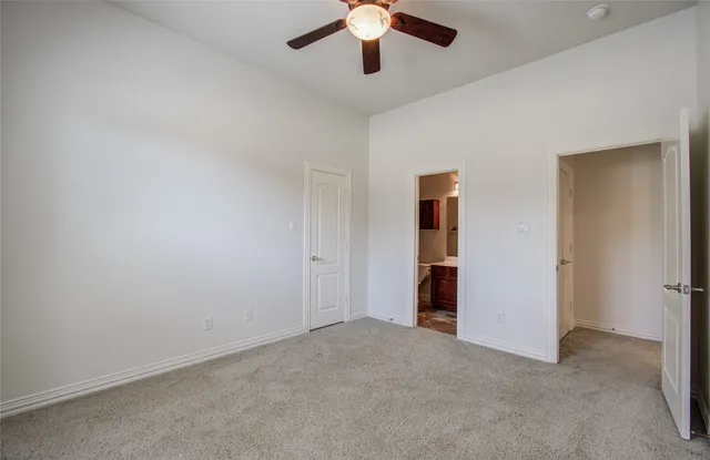 an empty room with chandelier fan