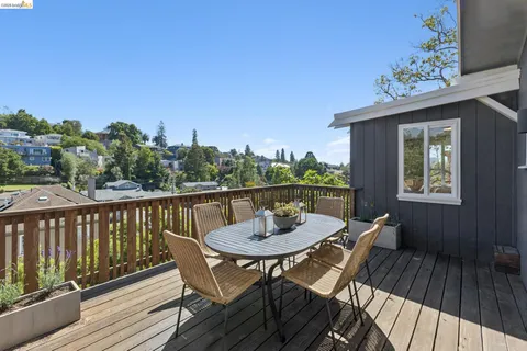a balcony with wooden floor and outdoor seating