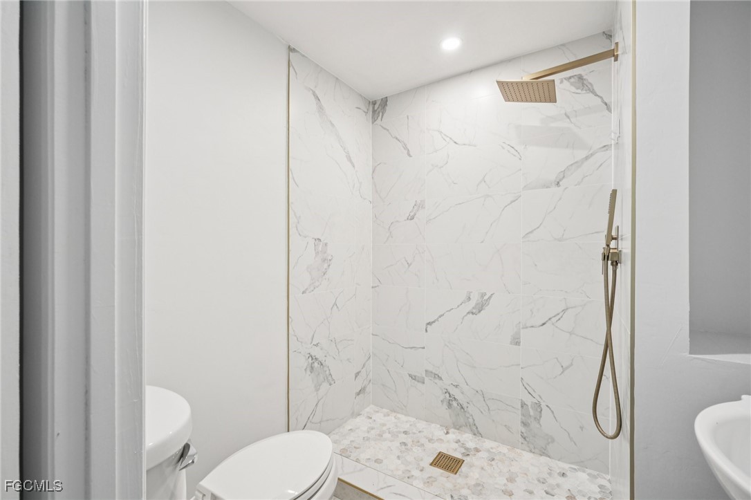 18472 Iris Road Fort Myers, FL 33967 - Photo 13 of 27 a bathroom with a toilet and shower
