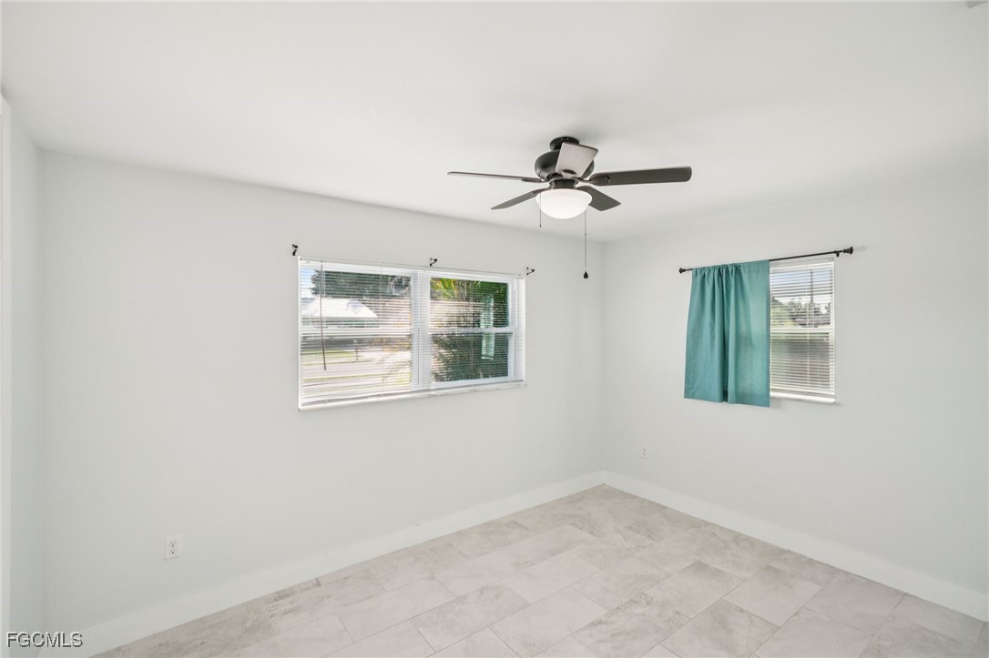 18472 Iris Road Fort Myers, FL 33967 - Photo 14 of 27 an empty room with window and ceiling fan