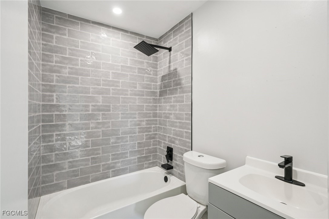 18472 Iris Road Fort Myers, FL 33967 - Photo 18 of 27 a bathroom with a bathtub shower sink vanity and toilet