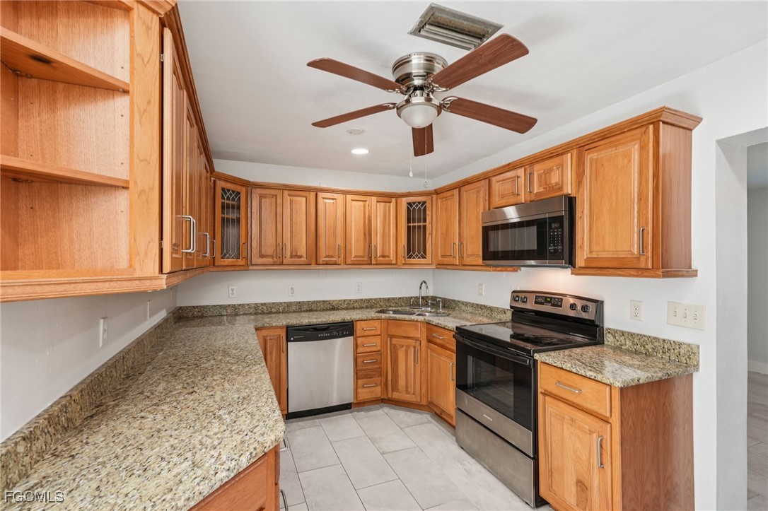 18472 Iris Road Fort Myers, FL 33967 - Photo 5 of 27 a kitchen with stainless steel appliances granite countertop a sink a stove and cabinets