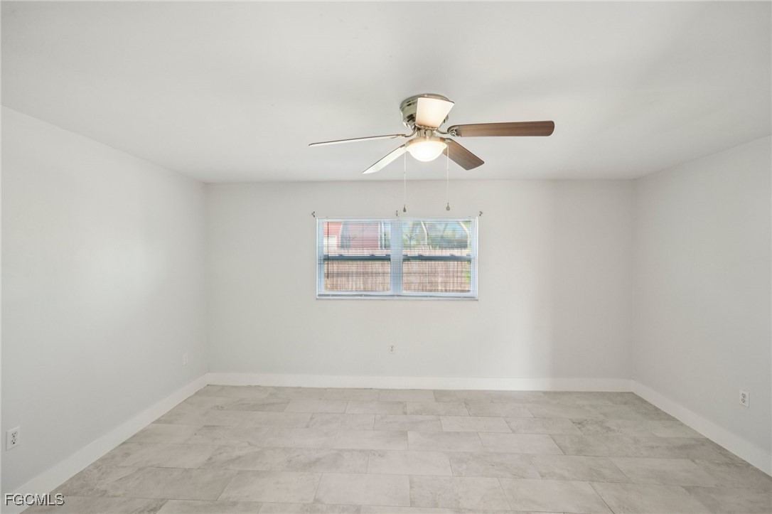 18472 Iris Road Fort Myers, FL 33967 - Photo 7 of 27 an empty room with a window and a fan