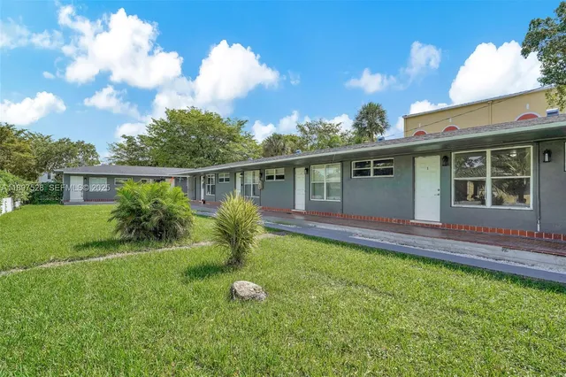 a view of a pathway both side of grassy field with shrub