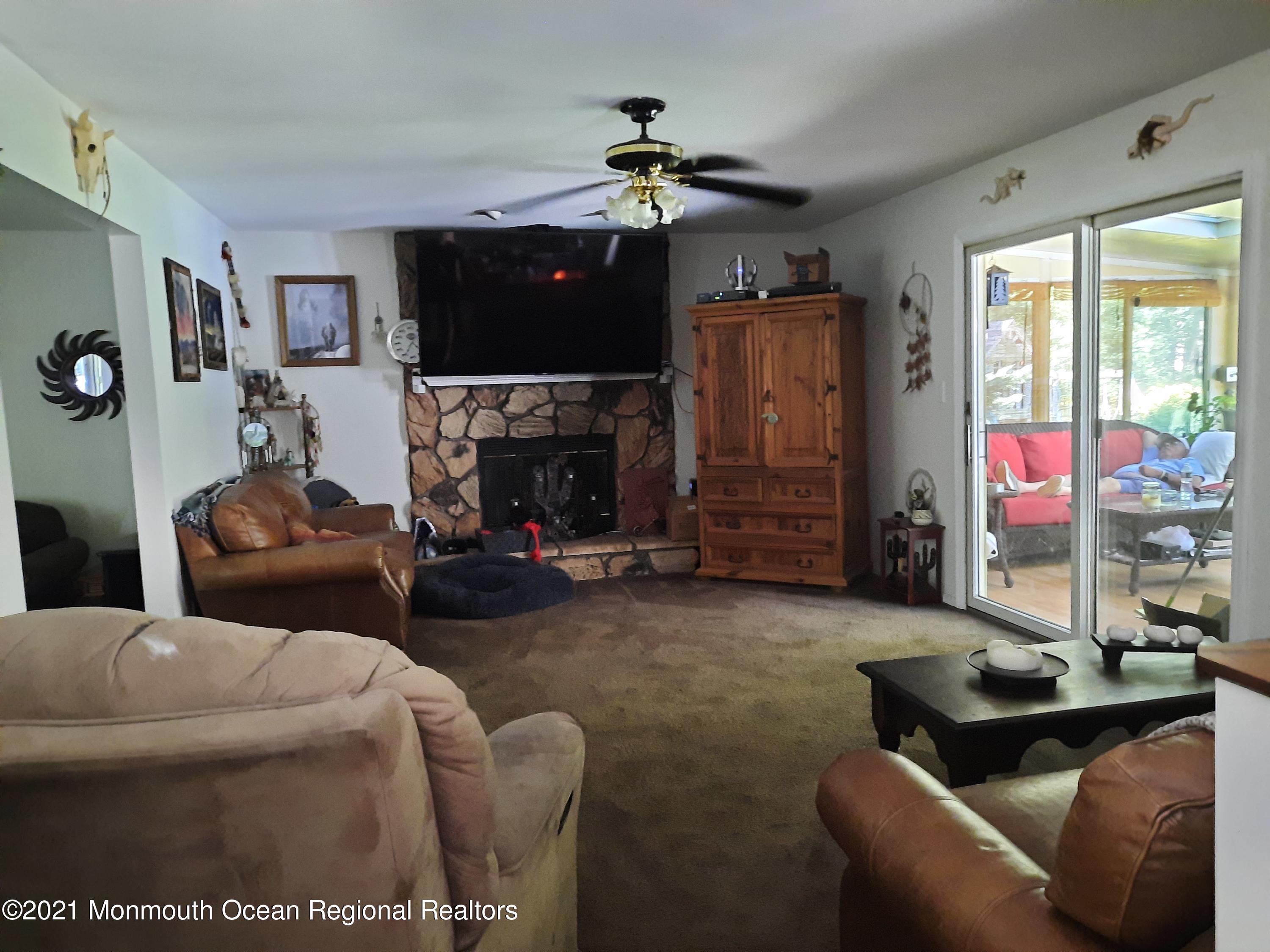 5 Dunhill Road Jackson, NJ 08527 - Photo 4 of 11 a living room with furniture a flat screen tv and a fireplace