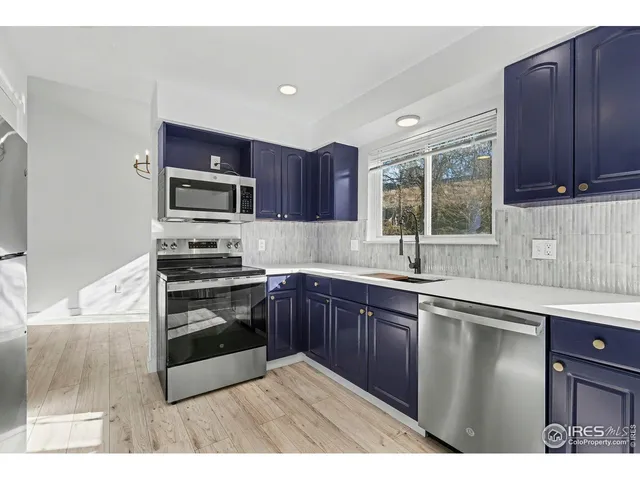 a kitchen with wooden cabinets and stainless steel appliances