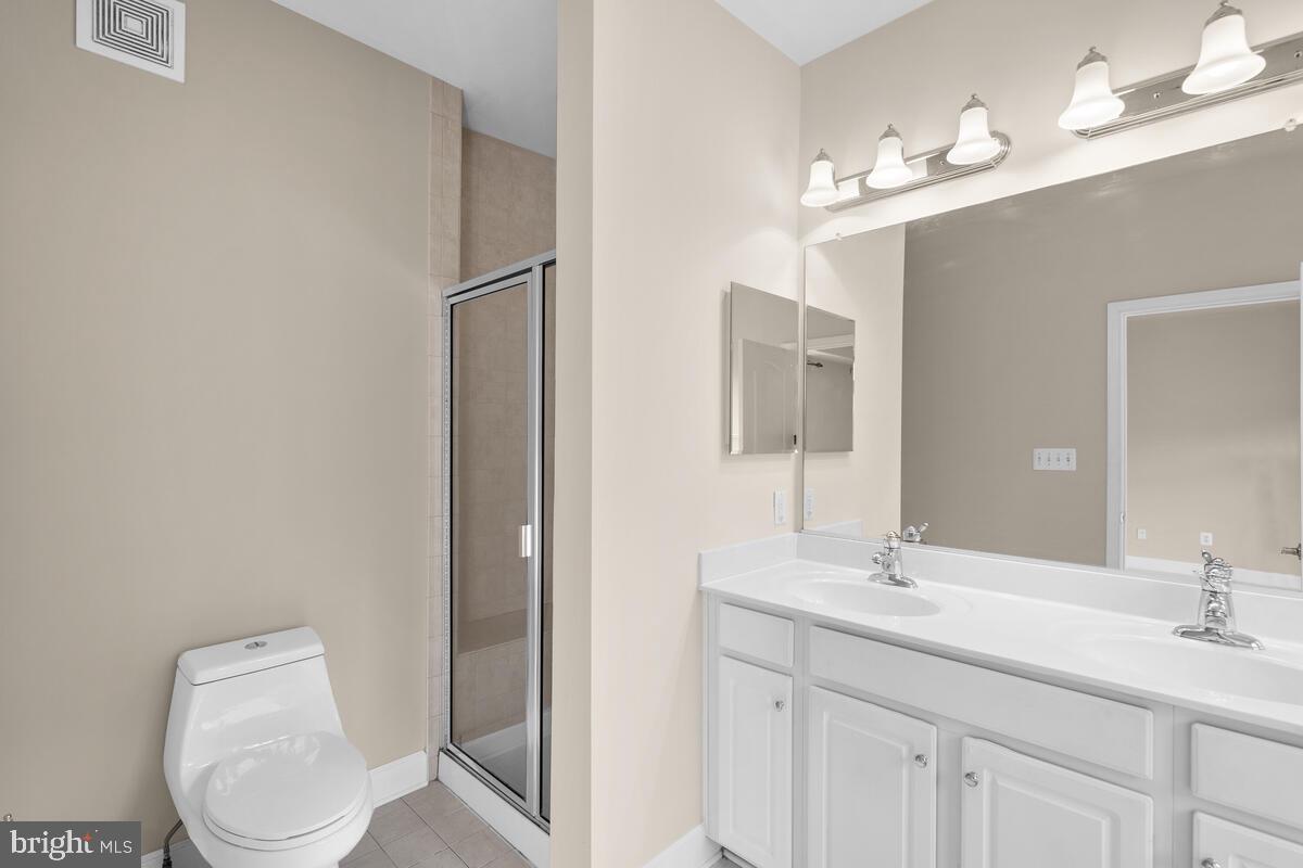 13626 Dover Cliffs Place Germantown, MD 20874 - Photo 20 of 32 a bathroom with a toilet a sink a mirror and vanity