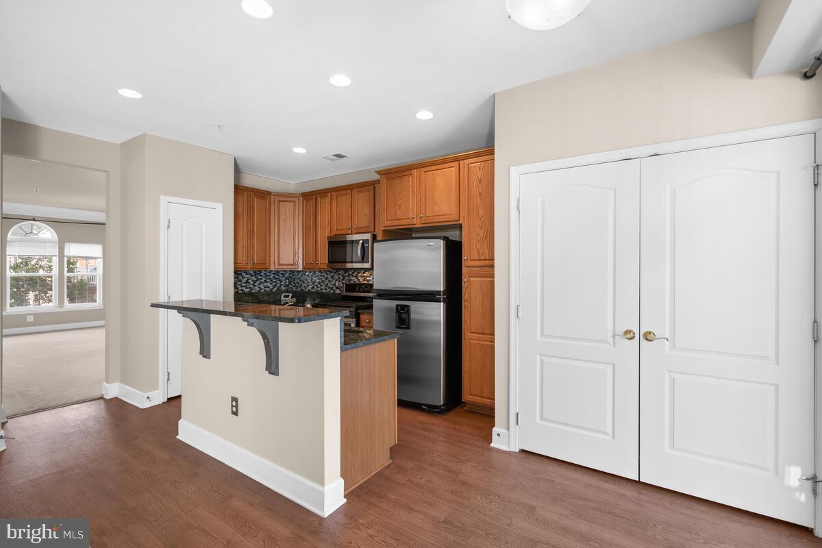 13626 Dover Cliffs Place Germantown, MD 20874 - Photo 5 of 32 a kitchen with stainless steel appliances granite countertop white cabinets and wooden floor