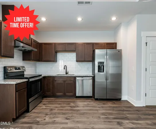 a kitchen with stainless steel appliances granite countertop a sink a stove a refrigerator and a microwave