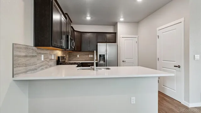 a view of a kitchen with a refrigerator a sink and cabinets