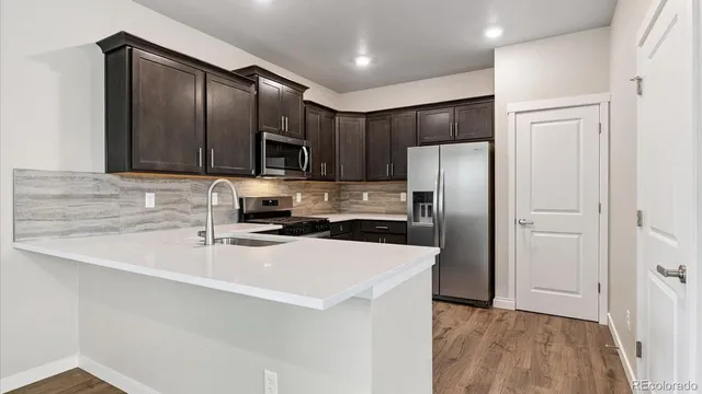 a kitchen with stainless steel appliances a refrigerator and a stove top oven