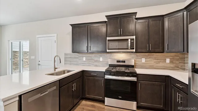 a kitchen with granite countertop stainless steel appliances a stove sink and microwave