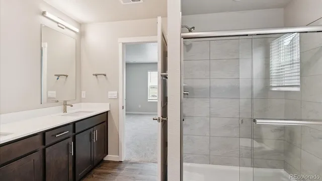 a bathroom with a double sink shower and a mirror