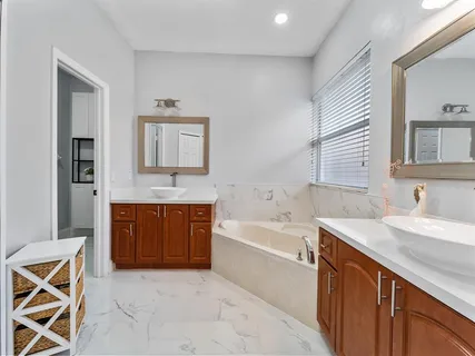 a spacious bathroom with a sink a mirror and a bathtub