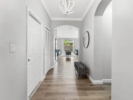 a hallway with a chandelier and a rug