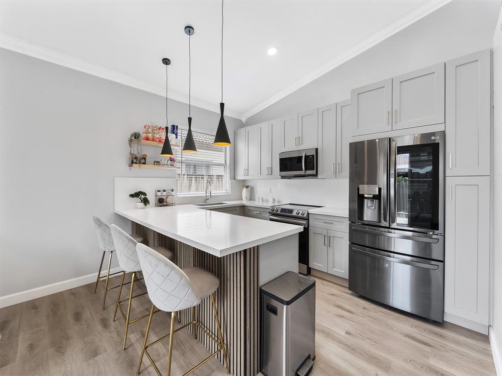 14815 Southwest 28 Lane Miami, FL 33185 - Photo 8 of 19 a kitchen with kitchen island a sink appliances and cabinets