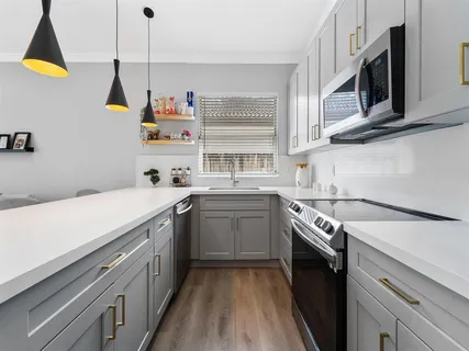 a kitchen with a sink a stove and cabinets