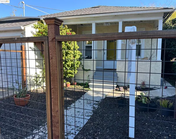 a view of a brick house with a floor to ceiling windows and wooden fence