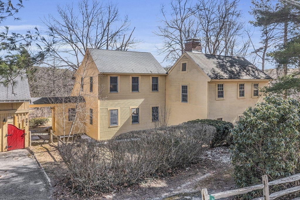 a view of a white house next to a road and yard