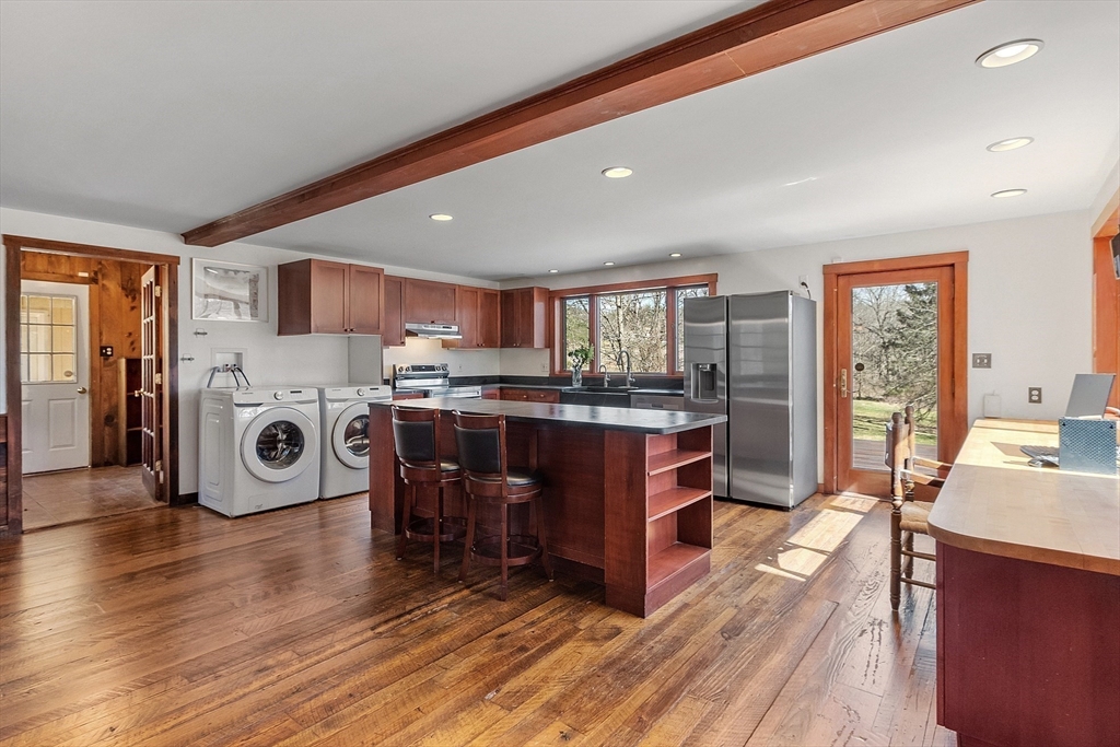 291 Still River Road Harvard, MA 01451 - Photo 11 of 42 a living room with a couch and a dining table with kitchen view