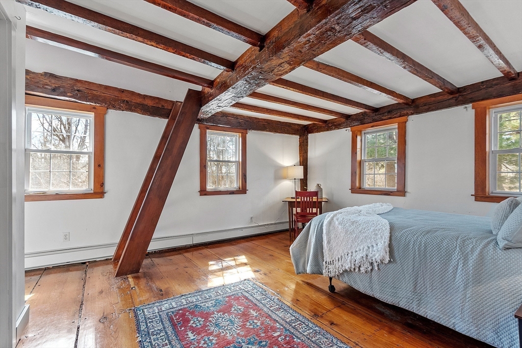 291 Still River Road Harvard, MA 01451 - Photo 20 of 42 a bed sitting in a bedroom next to a window