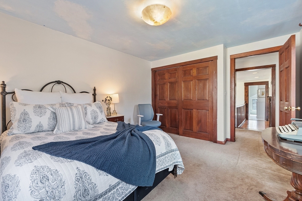 291 Still River Road Harvard, MA 01451 - Photo 30 of 42 a bedroom with a bed and a large mirror