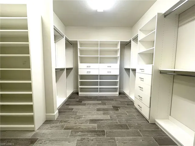 a view of walk in closet with empty racks