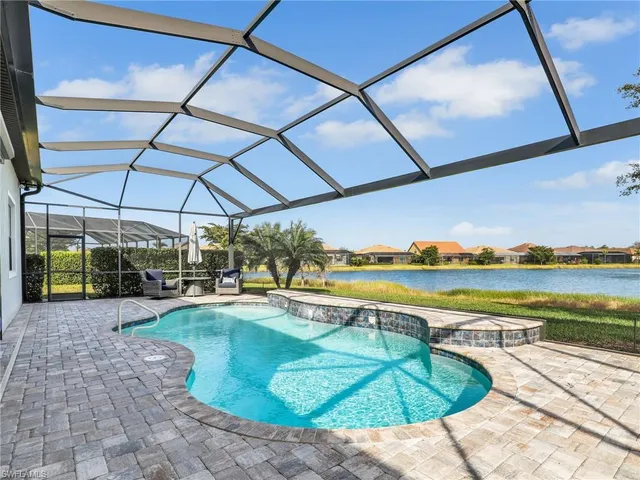 a view of a swimming pool with a lounge chairs in patio