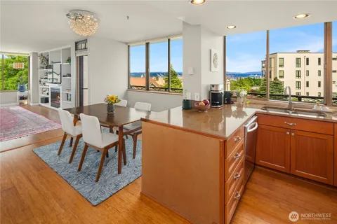 a kitchen with stainless steel appliances granite countertop a stove top oven a sink dishwasher and cabinets with wooden floor