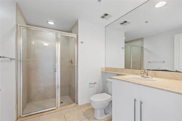 a bathroom with a granite countertop sink toilet and shower