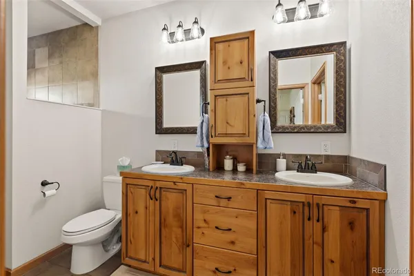 a bathroom with a toilet sink and mirror