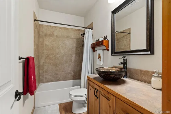 a bathroom with a granite countertop sink mirror toilet and bathtub